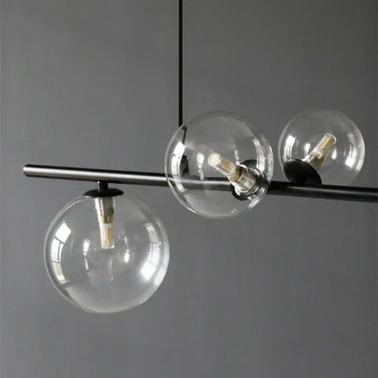 Modern black metal pendant light with three clear glass ball shades suitable for dining room decorbites glass ball pendant