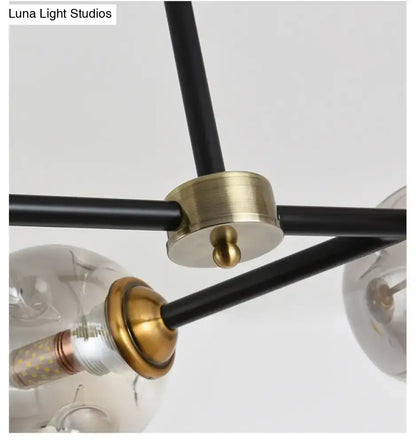 Modern black island pendant light with brass and spherical glass bulbs for dining room featuring stained glass accents