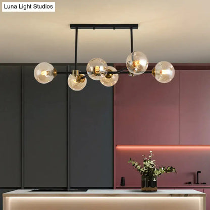 Modern black glass island pendant light with brass accents and clear glass globe bulbs for dining room illumination