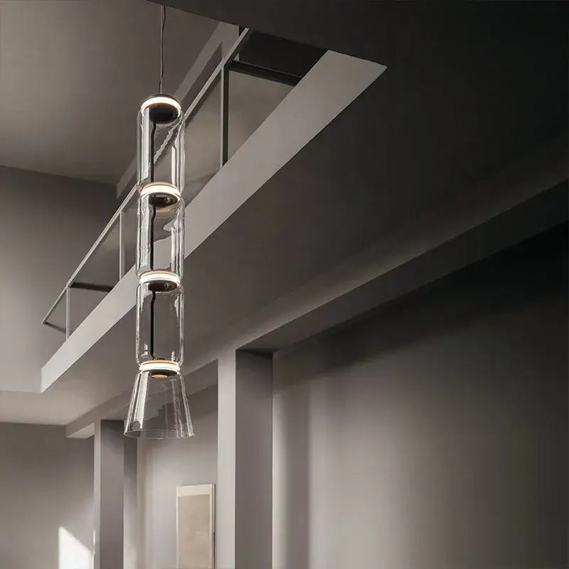 Modern black glass led pendant light with three stacked cylindrical sections and warm lighting for dining room use