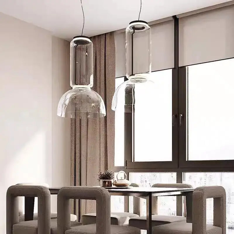 Two modern black glass led pendant lights with clear cylindrical and dome-shaped fixtures for dining room use