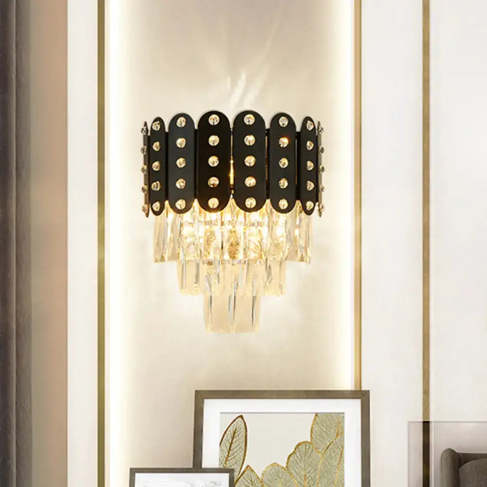 Modern black and gold 3-tiered wall-mounted light with clear faceted crystal oval panels and sparkling rhinestones