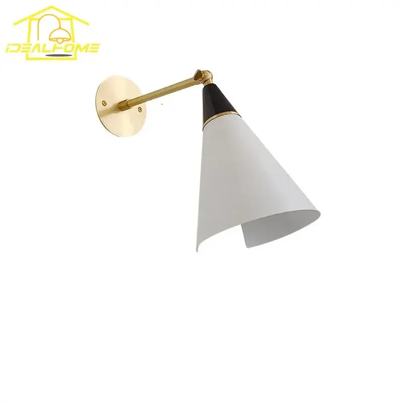 A modern black and gold wall lamp decorbites athena with a brass arm and white conical shade for kitchen sconce
