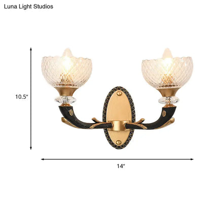 Modern black and gold metal black sconce with two clear prismatic glass shades for bedroom lighting