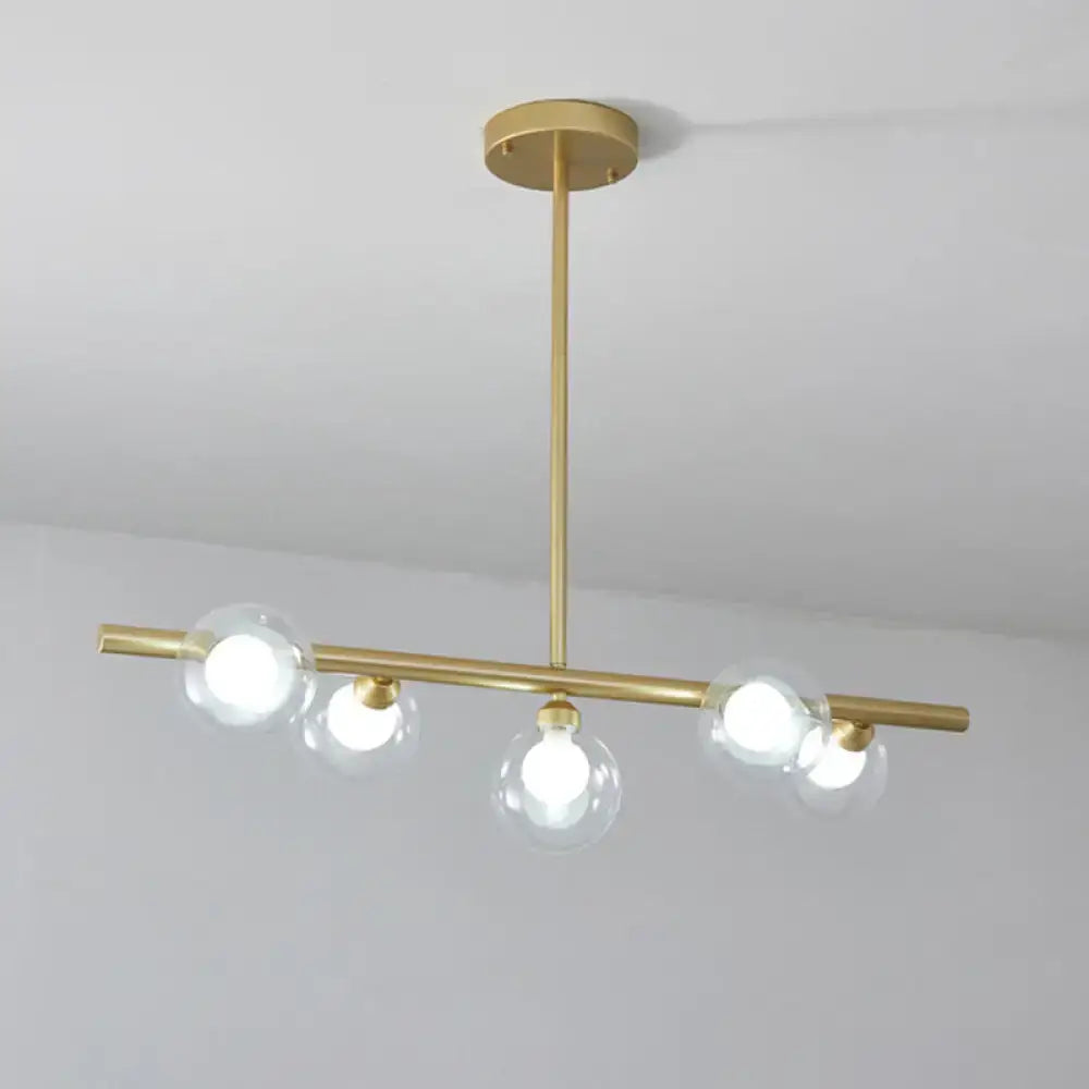 Modern black and gold ceiling light with five brass clear glass globe bulbs for dining room island use