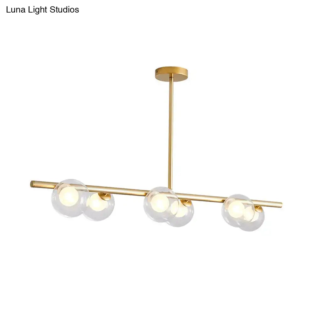 Modern black and gold ceiling light with gold-toned frame and bubble clear glass globe shades for dining room island