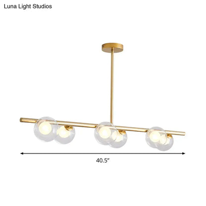 Modern black and gold ceiling light with gold-toned bar and three bubble clear glass shades for dining room island use