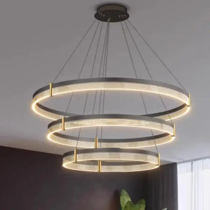 Modern black and gold three-tiered pendant light with sleek black acrylic led rings for stylish living room decorbites lighting