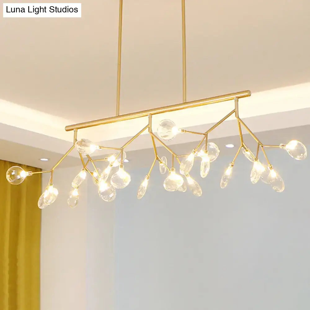Modern black and gold dining room chandelier with clear glass droplets and branching metal arms in gold tone