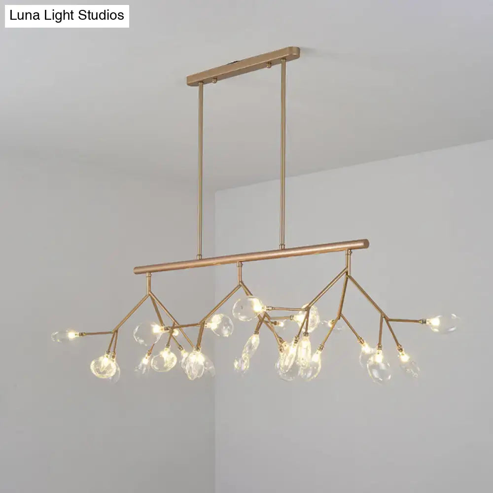 A modern black and gold dining room chandelier with clear glass globe bulbs and a brass-toned branching design