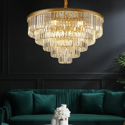Modern black and gold crystal ceiling chandelier with clear glass rods above an emerald green velvet sofa