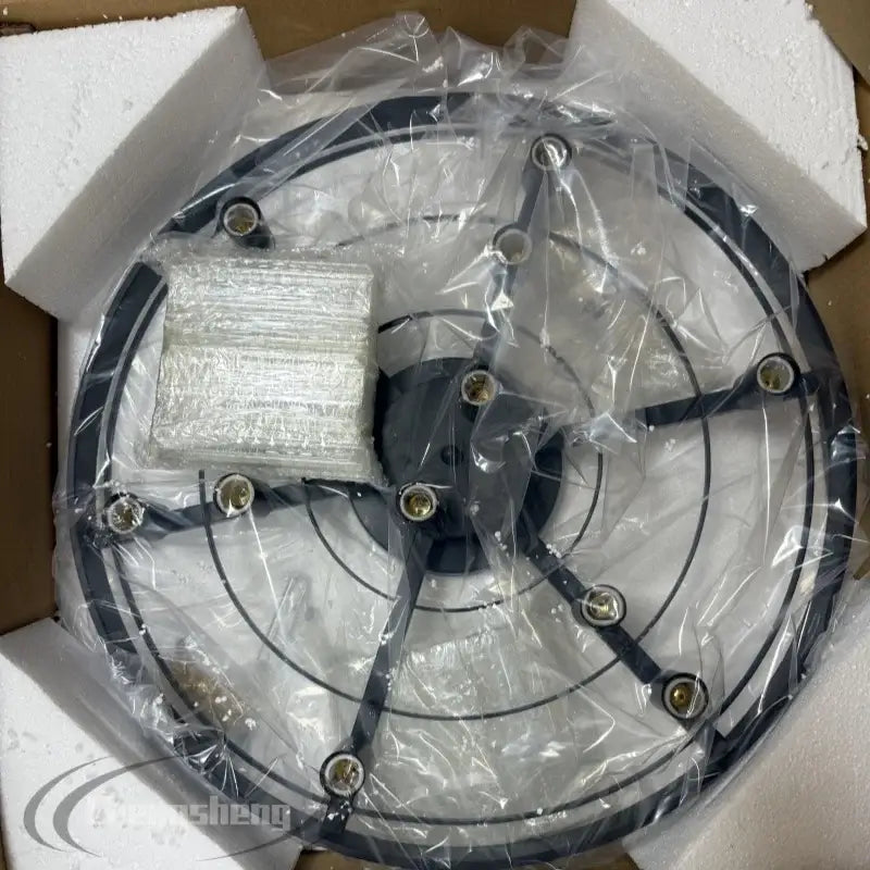 Black circular fan base with metallic gold metal finish mounting hardware wrapped in clear plastic for pendant light sources