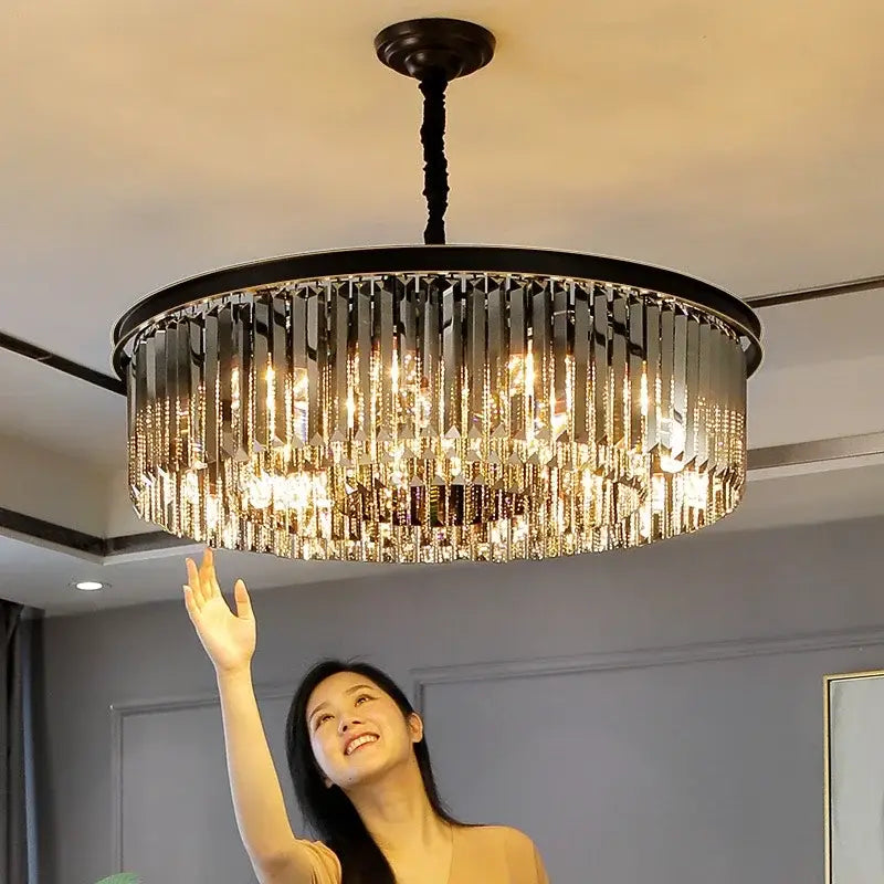 Modern black and gold pendant light with metal finish and cascading crystal prisms on a chain pendant for dining rooms