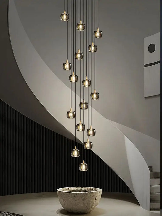 A modern black and gold crystal chandelier led pendant light with multiple hanging glass globe lights for staircases