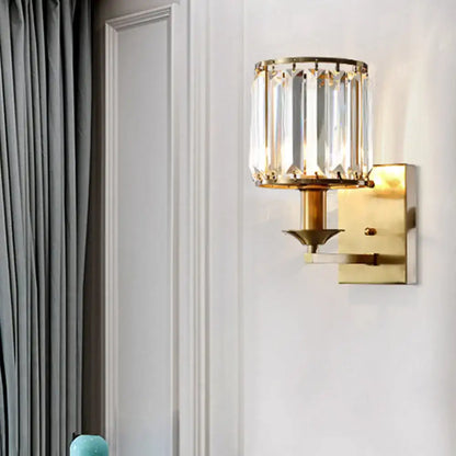 Modern black and gold sconce light fixture with gold-toned vertical crystal prisms and direct wired electric power