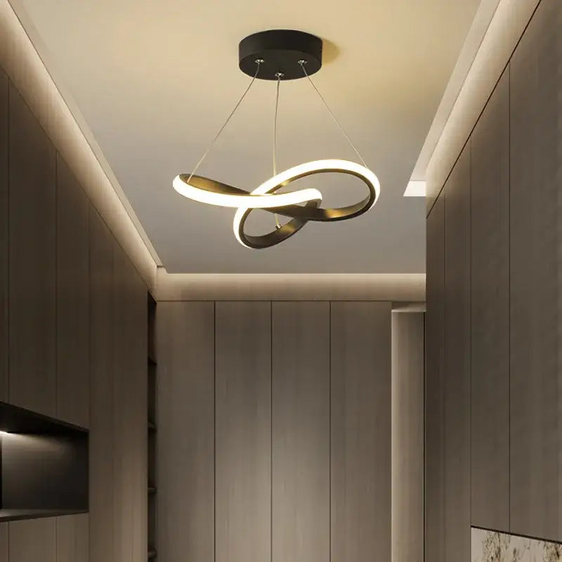 Modern black and gold decorbites contemporary chandelier with infinity loop design and sleek LED illumination for dining room
