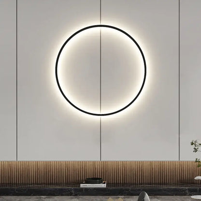 A sleek black and gold dimmable black wall lamp with a warm glowing ring for modern living room decorbites lighting