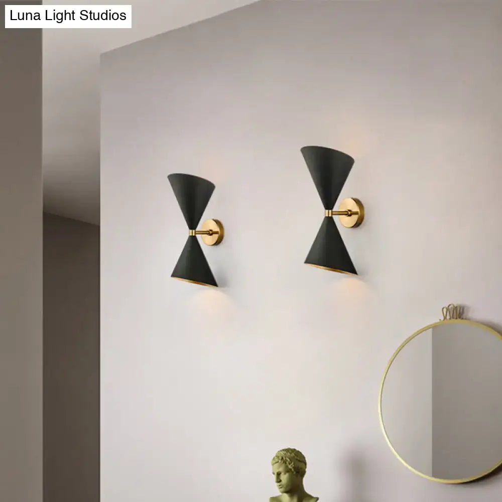 Modern black and gold wall lamp featuring two double cone-shaped shades with gold-toned metal fixtures for hallway use