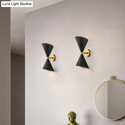 Modern black and gold wall lamp featuring two double cone-shaped shades with gold-toned metal fixtures for hallway use