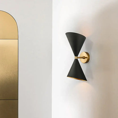 Modern black and gold wall lamp featuring two double cone-shaped shades with gold-toned mounting plate for hallway use