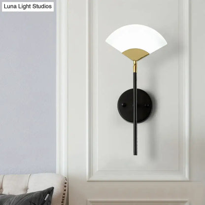 Modern black and gold fan wall mount light with white glass shade and metal accent for bedroom lighting
