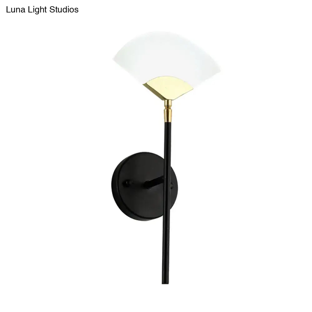 Modern black and gold wall mount light featuring a sleek brass design with a frosted glass shade for bedroom use
