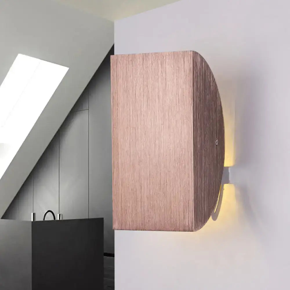 A sleek modern black and gold folded wall light sconce with warm wood-grain finish for bedroom decor