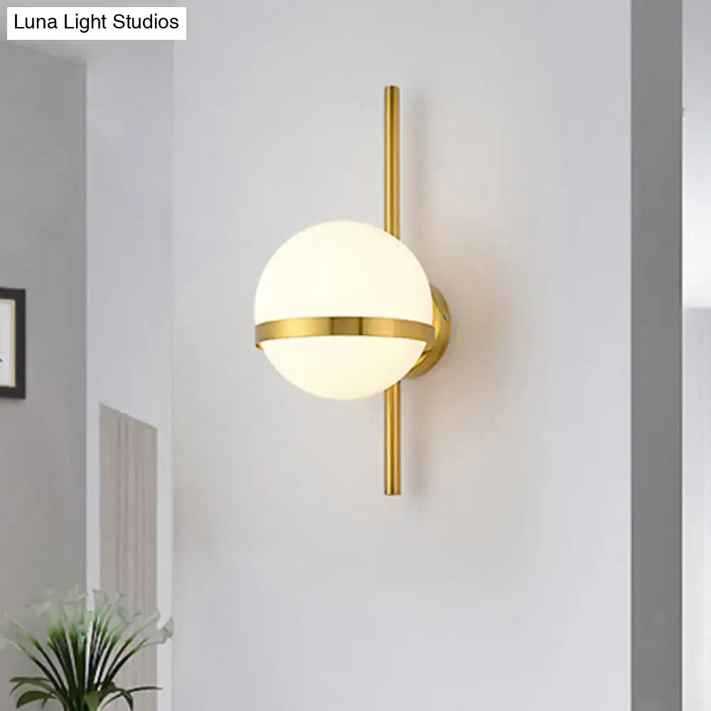 Modern black gold glass shade wall sconce featuring a gold-toned spherical frosted glass globe and minimalist vertical rod