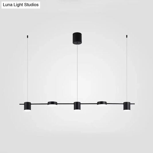 Modern black and gold ceiling light fixture featuring four minimalist cylindrical pendants for kitchen island lighting