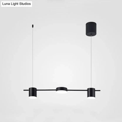 Modern black and gold ceiling light fixture with three minimalist cylindrical pendant lights for kitchen island use
