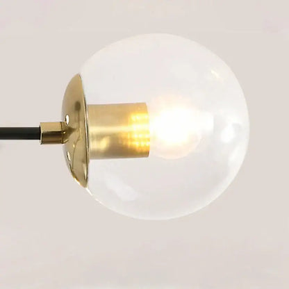 Modern black and gold led chandelier with a glowing glass globe pendant light and brass finish by decorbites black
