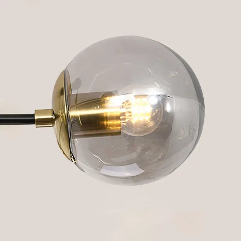 A modern black and gold led chandelier glass globe lamp with a brass base and exposed filament bulb by decorbites black