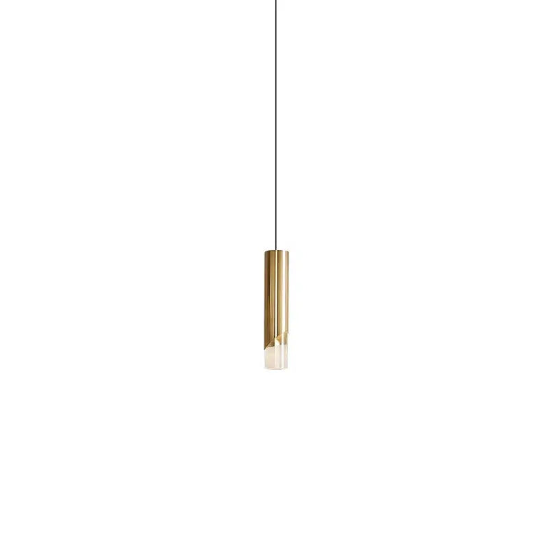 Minimalist cylindrical pendant light with brushed gold finish and clear glass base made of high-quality die-cast aluminum