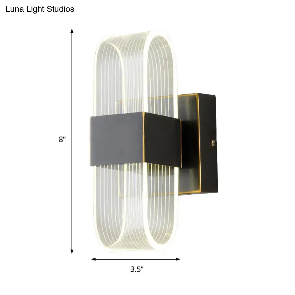 Modern black and gold sconce light with curved translucent acrylic body and vertical ridges for bedroom wall mount