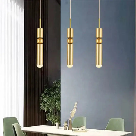 Three modern gold led tube pendant lights with black gold decorbites finish hang in kitchen setting