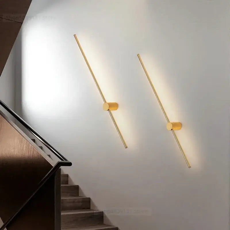 Two gold-toned minimalist led wall lamps with cylindrical bases emit warm light for modern living room decorbites led wall use
