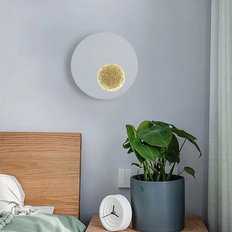 Modern black and gold led wall lights circular sconce with white matte finish and textured gold center emitting warm light