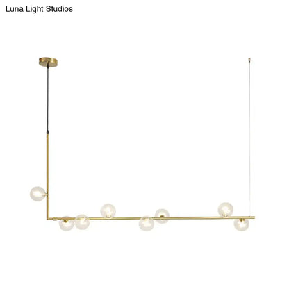 Modern black gold linear chandelier with gold-toned frame and clear glass globe bulbs for dining room island lighting