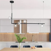 Modern black and gold linear chandelier featuring clear glass globe bulbs for dining room or kitchen island lighting