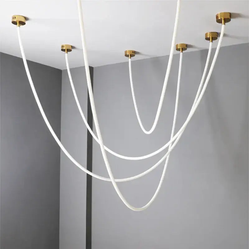 Modern white cable chandelier with gold-toned ceiling mounts as a pendant light dining room light source