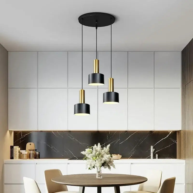 Modern black and gold metal finish pendant light with cylindrical shades and brushed nickel ceiling mount for kitchen use