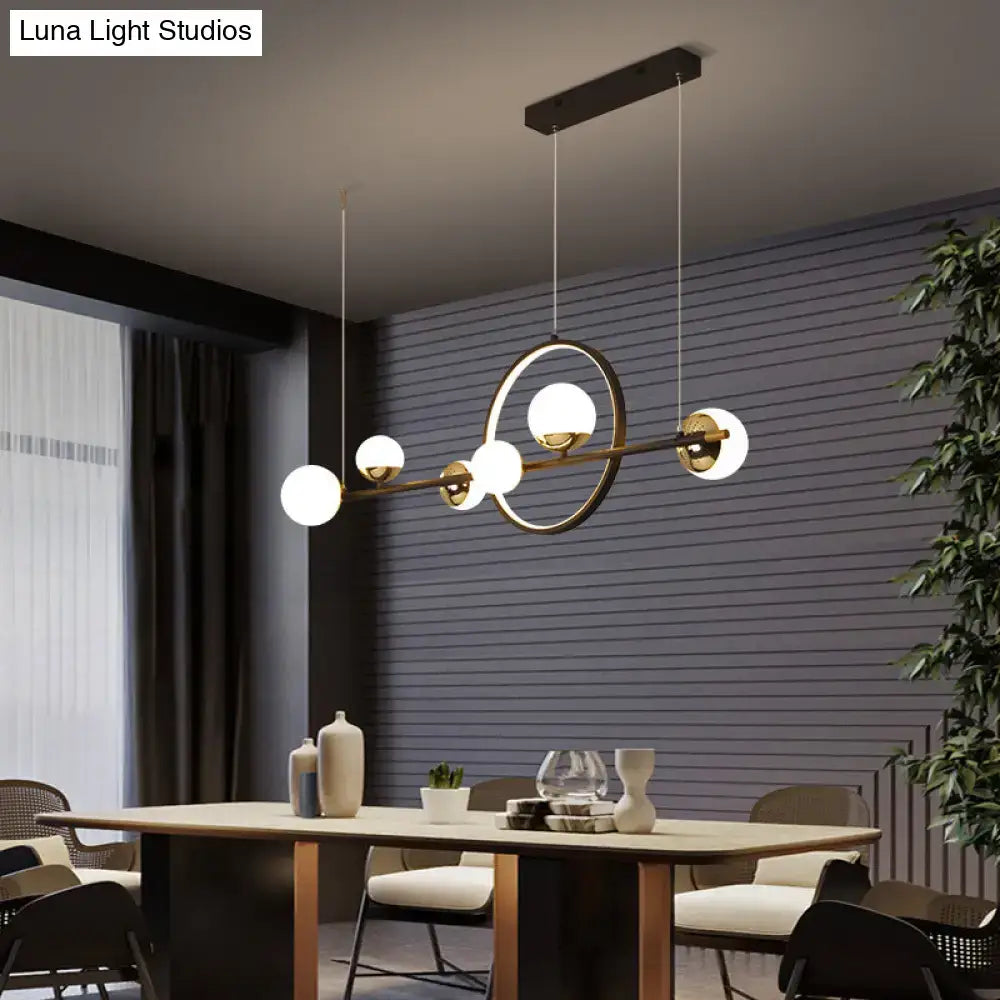 Modern gold-toned led pendant light with spherical white glass globes and sleek horizontal bar design for restaurants