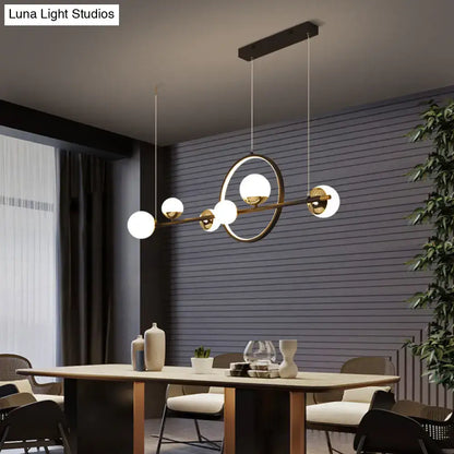 Modern gold-toned led pendant light with spherical white glass globes and sleek horizontal bar design for restaurants