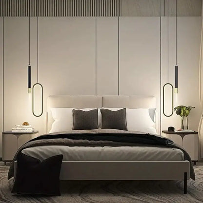 Modern minimalist bed with light gray upholstered headboard and frame under modern black and gold oval pendant light white light source