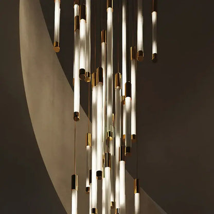 Modern black and gold pendant chandelier with translucent glass tubes and polished metal caps as a staircase pendant light
