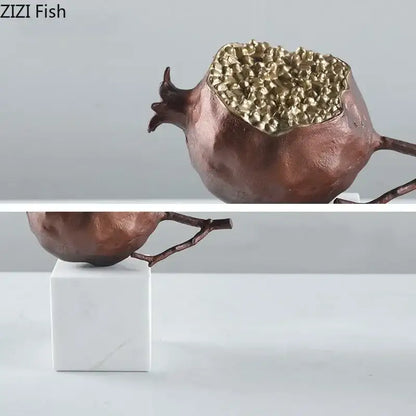 Modern black and gold golden pomegranate sculpture with textured interior and branch for living room decor by decorbites