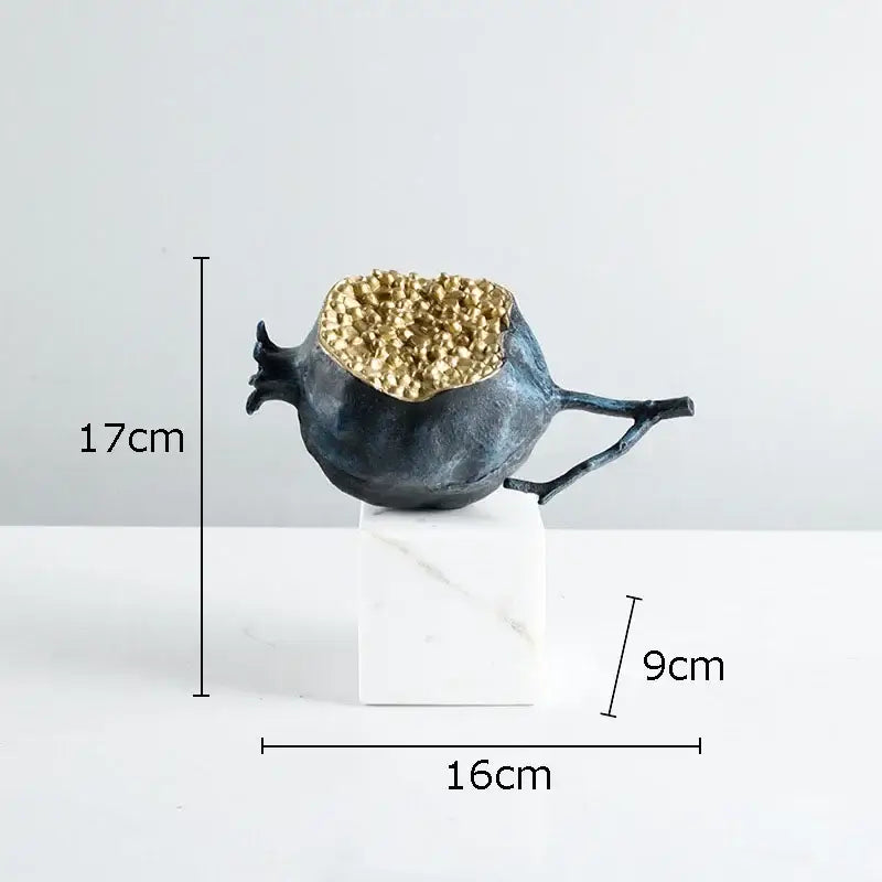 Modern black and gold pomegranate sculpture with dark blue textured resin and golden crystalline interior on marble base decorbites golden pomegranate