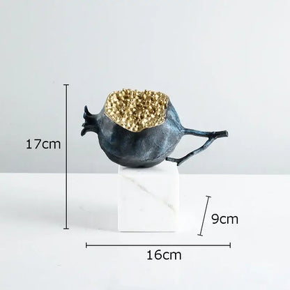 Modern black and gold pomegranate sculpture with dark blue textured resin and golden crystalline interior on marble base decorbites golden pomegranate