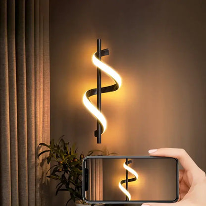 Modern black and gold spiral pendant light with copper lamp body and warm glowing led wall sconce for dining room
