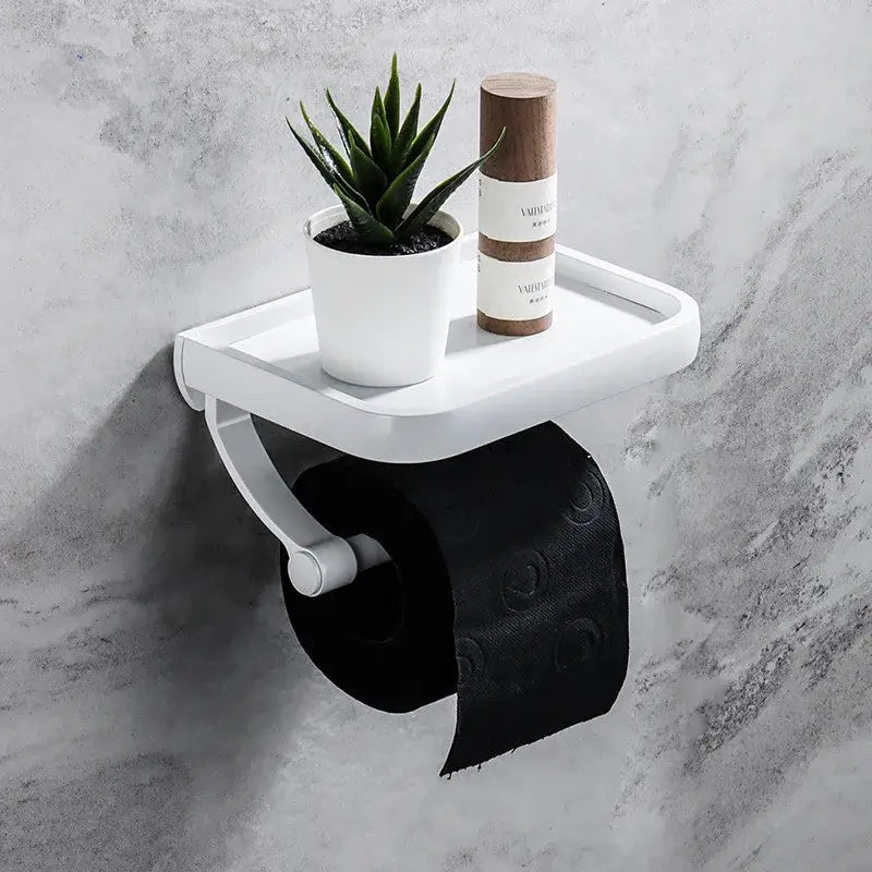 Modern white plastic tissue paper holder with integrated shelf holding black patterned tissue paper and aloe vera plant